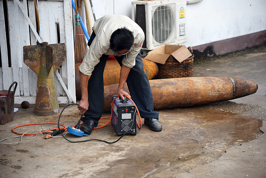 Man working on a old bomb at UXO center